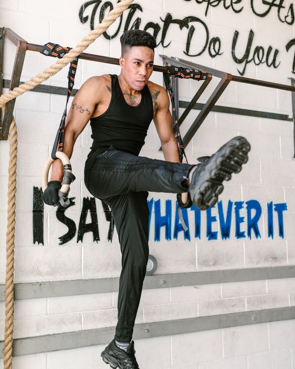 Man performing a controlled strength exercise in a dark, focused environment.